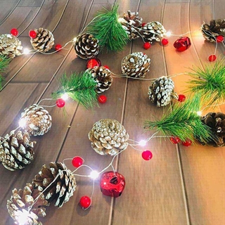 Julelyskæde med pinjekogler, fyrretræs grene, bær og klokker